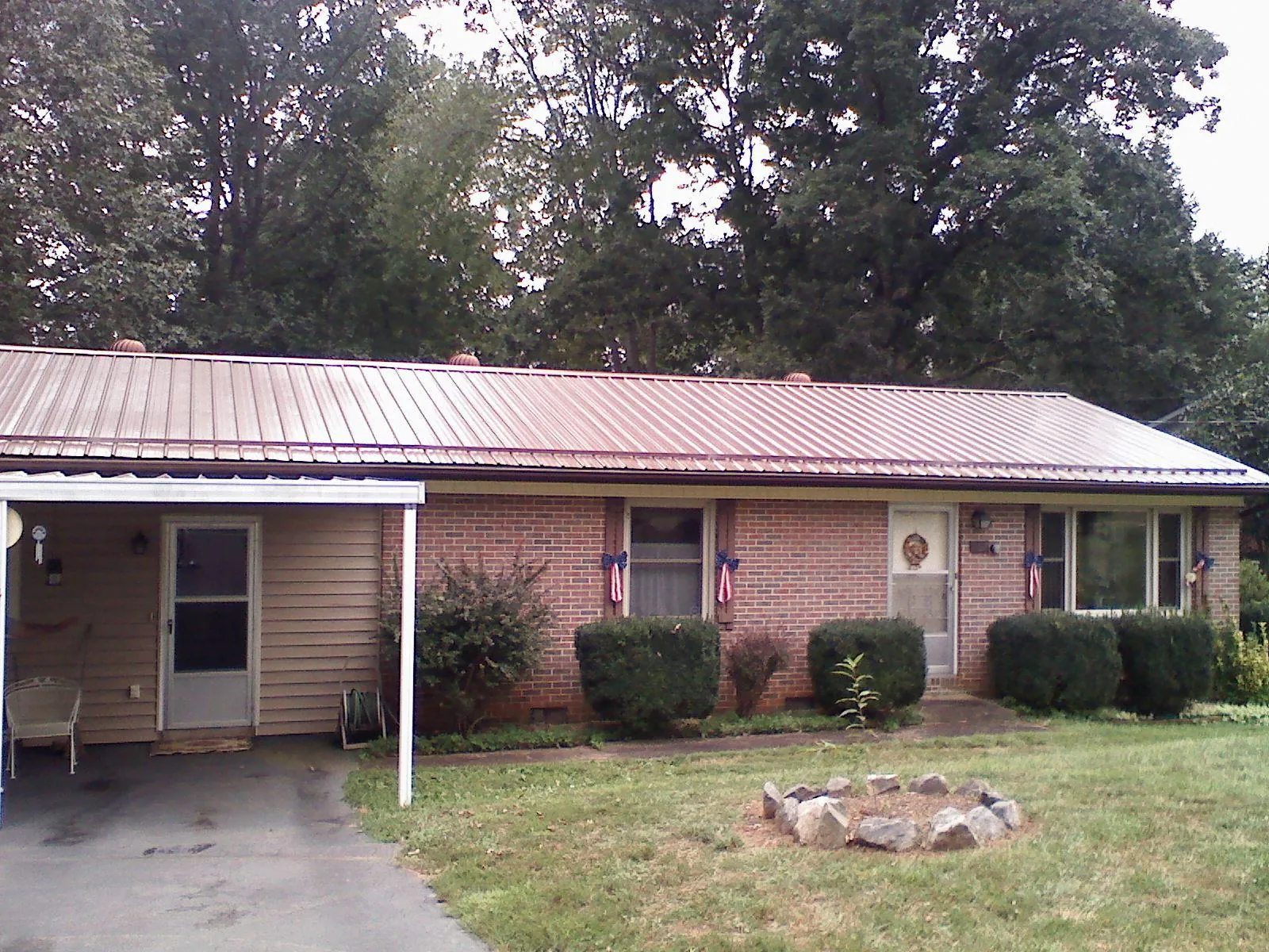 Bronze metal roof and carport on a brick ranch home — Roof Repair work by our crew in Cottonport